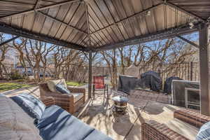 View of patio with a gazebo, grilling area, outdoor lounge area, and a fenced backyard