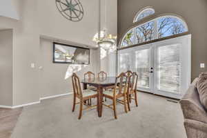 Dining space featuring plenty of natural light, light colored carpet, and visible vents