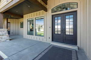Entrance to property featuring beautiful metal French doors and board and batten siding