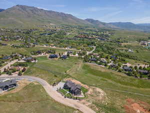 Aerial view of property's location with a mountain backdrop and nearby suburban area