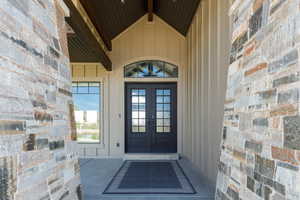 Doorway to property with metal French doors and board and batten siding