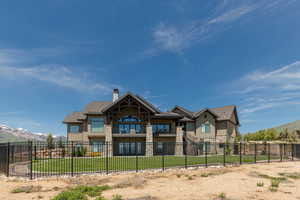 Back of property with stone siding, a chimney, a mountain view, and board and batten siding