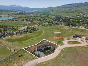 Aerial view of property and surrounding area with property parcel outlined and a water and mountain view