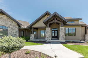 View of front façade with metal French doors, a standing seam roof, stone siding, and metal roof