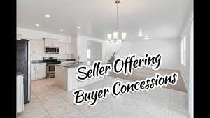 Kitchen with a sink, a chandelier, stainless steel appliances, light tile patterned floors, and hanging light fixtures