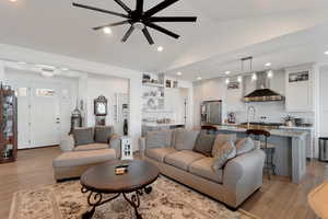 Living room with light wood-style flooring, ceiling fan, lofted ceiling, and recessed lighting