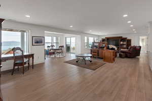 Living room with recessed lighting, light wood-style floors, baseboards, and visible vents