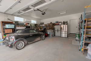 Garage with a garage door opener and stainless steel refrigerator with ice dispenser