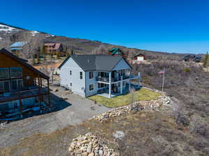 Back of house featuring a patio area, a yard, and a mountain view