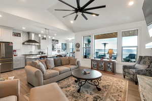 Living room with light wood-style floors, ceiling fan, plenty of natural light, and recessed lighting