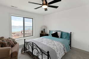 Bedroom featuring baseboards, light colored carpet, ceiling fan, and visible vents