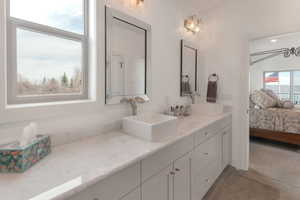 Bathroom with double vanity, ensuite bath, and a sink