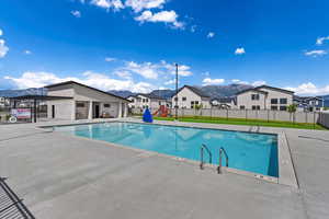 Pool featuring a mountain view, a residential view, and fence