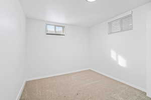 Basement featuring baseboards and carpet floors