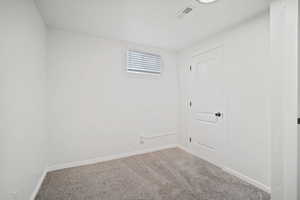Unfurnished room featuring carpet flooring, baseboards, and visible vents