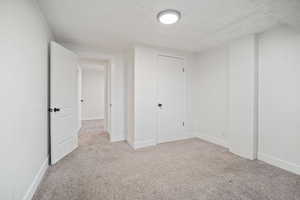 Unfurnished bedroom featuring carpet floors and a textured ceiling
