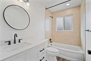 Bathroom featuring toilet, vanity, bathtub / shower combination, and wood finished floors
