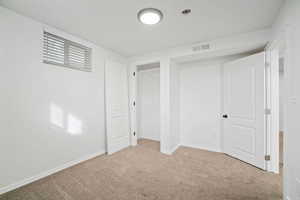 Basement featuring visible vents, baseboards, and carpet