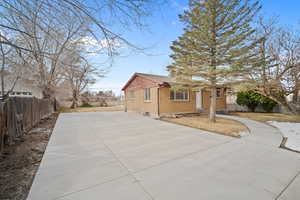 Exterior space with brick siding, driveway, and fence