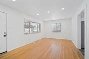 Spare room featuring a wealth of natural light, visible vents, light wood-style floors, and recessed lighting