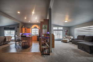 Carpeted living area featuring recessed lighting, a sink, and vaulted ceiling