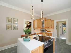 Kitchen with glass insert cabinets, baseboards, light countertops, stainless steel range with electric cooktop, and marble finish floor