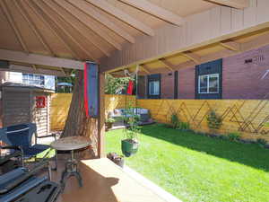 View of patio with an outdoor hangout area and fence