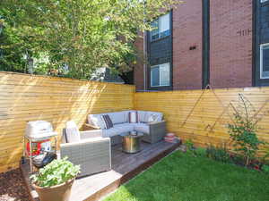 Wooden terrace with area for grilling, an outdoor living space, and fence