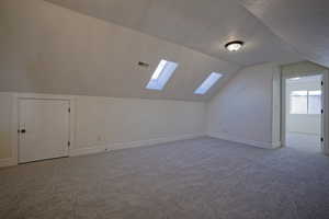 Bonus room with skylights by bedrooms with brand new carpet