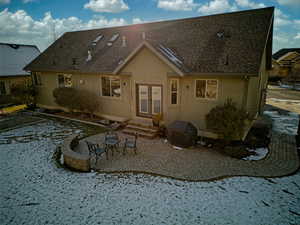 Back of house with a shingled roof, a patio area,  and stucco siding