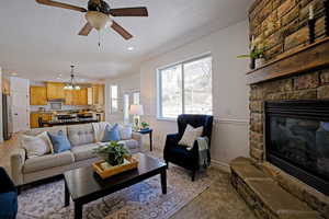 Living area with a ceiling fan, recessed lighting, a fireplace, and light colored carpet