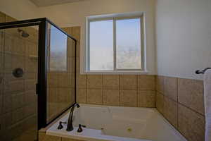 Bathroom with a shower stall and a jetted tub