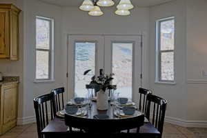 Dining area featuring light tile patterned floors, and a notable chandelier