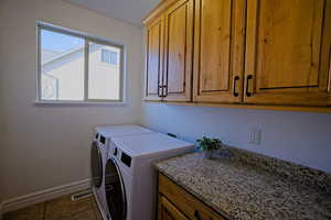 Washroom featuring dark tile patterned flooring and cabinet space