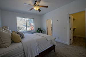 Bedroom with a walk in closet, bathroom, ceiling fan and private mountain views