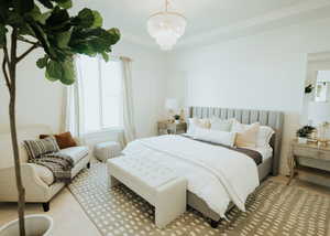 Bedroom with light colored carpet and a chandelier