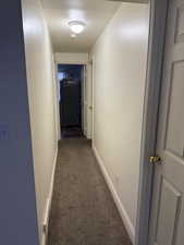 Corridor featuring baseboards and carpet