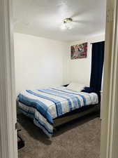 Bedroom with a textured ceiling and carpet floors