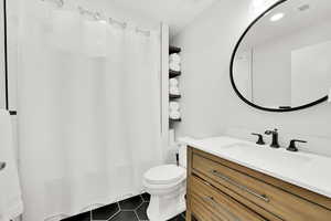 Bathroom featuring tile patterned flooring, visible vents, toilet, and vanity