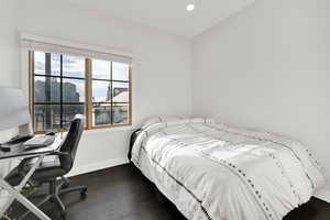 Bedroom featuring dark wood finished floors, recessed lighting, and baseboards