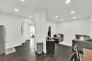 Living area with recessed lighting, baseboards, and dark wood-type flooring