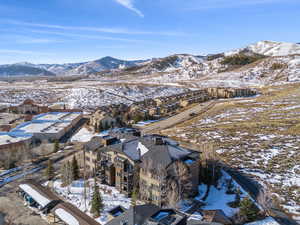 Snowy aerial view featuring a residential view and a mountain view