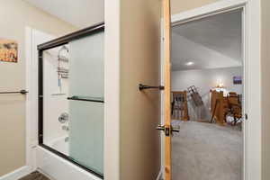 Full bath featuring shower / bath combination with glass door