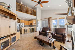 Living area featuring visible vents, ceiling fan, recessed lighting, light wood-style flooring, and high vaulted ceiling