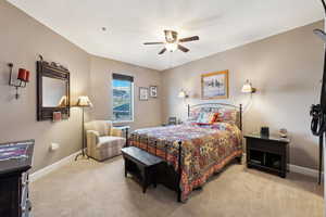 Bedroom with baseboards, light colored carpet, and a ceiling fan