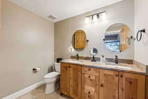 Full bath with tile patterned flooring, toilet, visible vents, and a sink