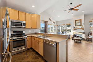 Kitchen with a sink, stainless steel appliances, open floor plan, and light brown cabinetry