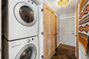 Clothes washing area featuring stacked washer and dryer