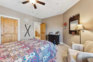 Bedroom featuring a ceiling fan, light colored carpet, visible vents, and baseboards