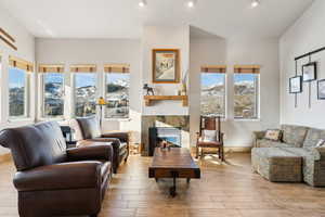 Living area with a mountain view, recessed lighting, a tile fireplace, and wood finished floors